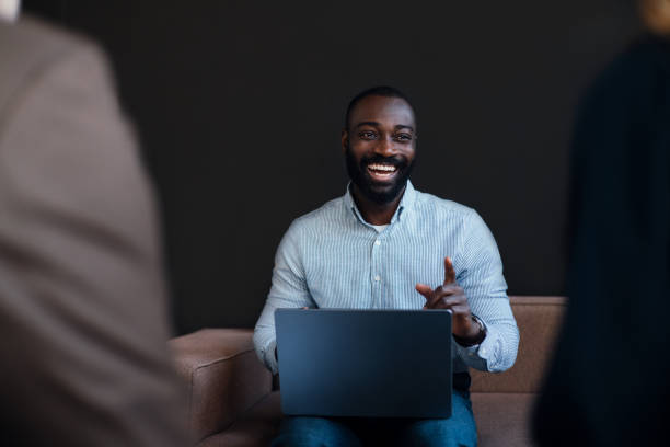 istock Smiling Professional in a Business Meeting Using Laptop in an Office 2203913971