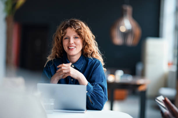 istock Woman Smiling While Working at a Modern Workplace with Laptop 2203914029