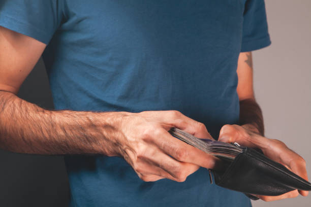 istock a man holding a wallet with a money in his hands. 2203914907