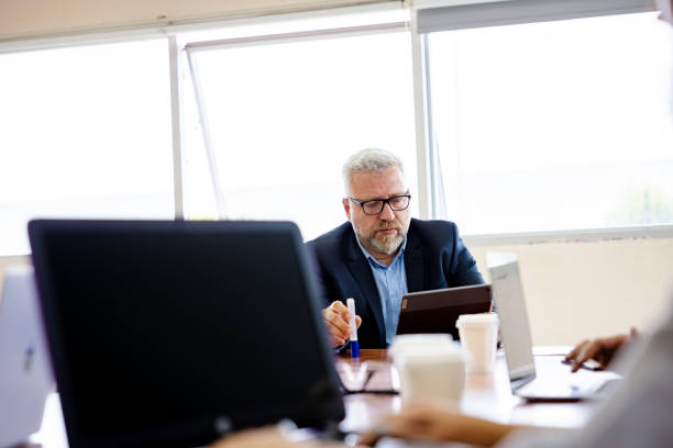 istock Businessman working on laptop in modern office with large windows. 2203916157