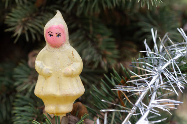 Festive decorations. Christmas angel on a tree branch. Handmade Christmas tree toy. Natural photo outdoors. Winter vacation. Happy New Year and Merry Christmas.