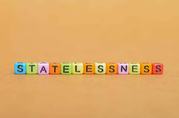 istock Colorful Letter Beads Spelling 'STATELESSNESS' on a Warm Background 2203917315