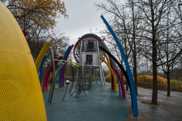 istock Colorful playground structure stands amidst autumn trees in a quiet park on a cloudy day 2203919710