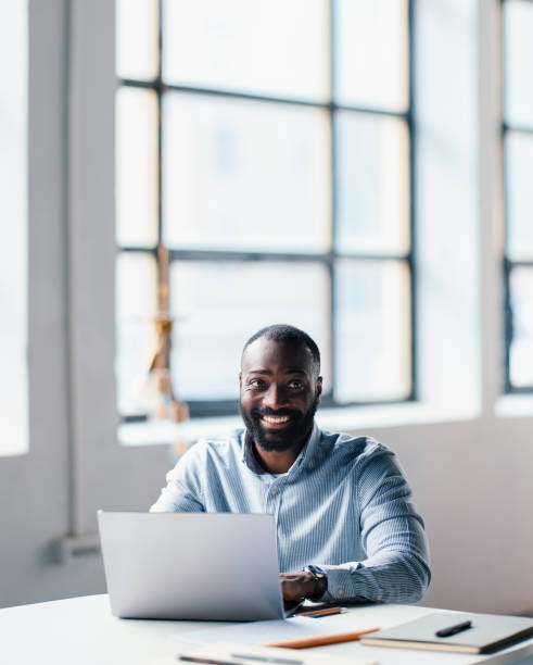 istock Professional Businessman Smiling Confidently While Working On Laptop in Modern Office 2203920730