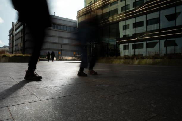 Legs of people walking on a paved city street
