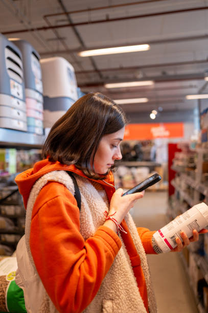 istock Customer using smartphone to compare prices in pet store 2203928762