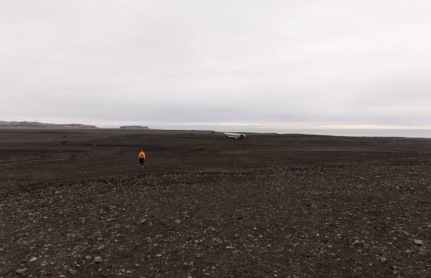 istock Geologist walking in a black volcanic desert in iceland 2203929754