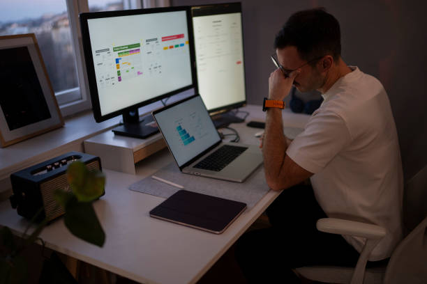 istock Stressed businessman working from home office using laptop and computer screens 2203935093