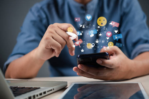 istock businessman using a smartphone with social media icons floating around, representing digital marketing and online communication. 2203935598