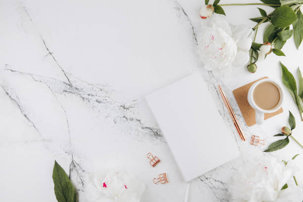 istock Women's marble table, diary mockup white peonies and coffee around, flat lay 2203935866