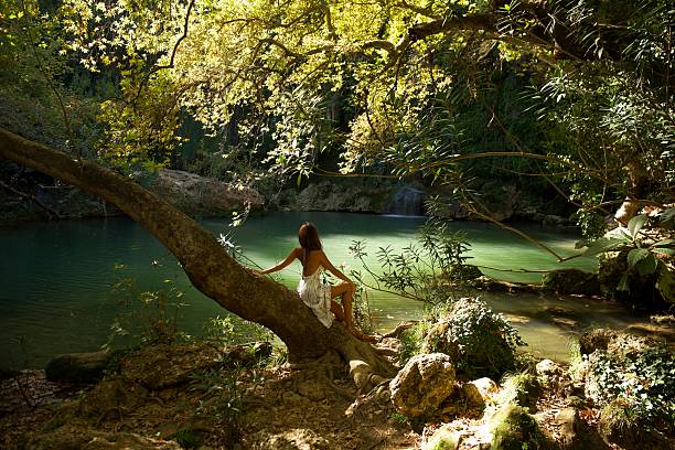 istock Woman Admiring Nature by a Waterfall Pool 2203937392