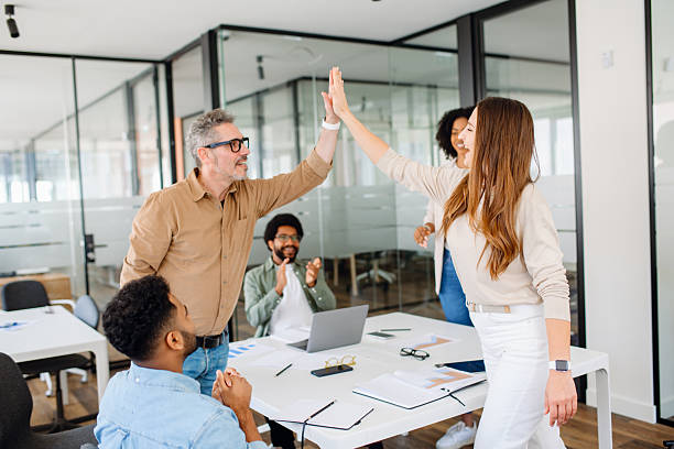 istock A diverse group of professionals in a modern office celebrates success with a high-five 2203938391