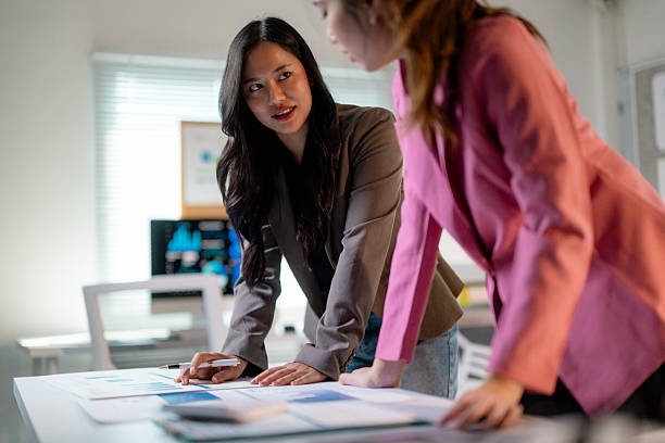 istock Young professionals analyzing financial charts, collaborating near modern workspace with natural lighting 2203939299