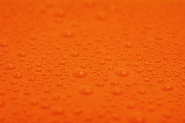 istock Water drops on orange plastic macro photo as a background. 2203940426