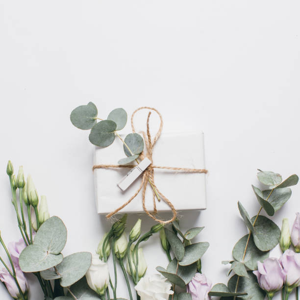 istock Creative arrangement pattern of box, eucalyptus and eustoma on a white background. Flat lay, top view. 2203940645