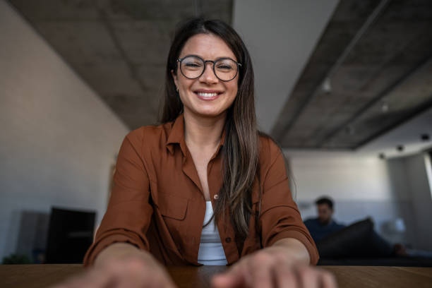 istock Smiling young woman making a video call from home office 2203940700