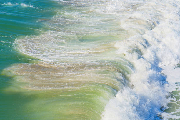 Intricate patterns formed by ocean waves as they break, displaying dynamic texture and movement.