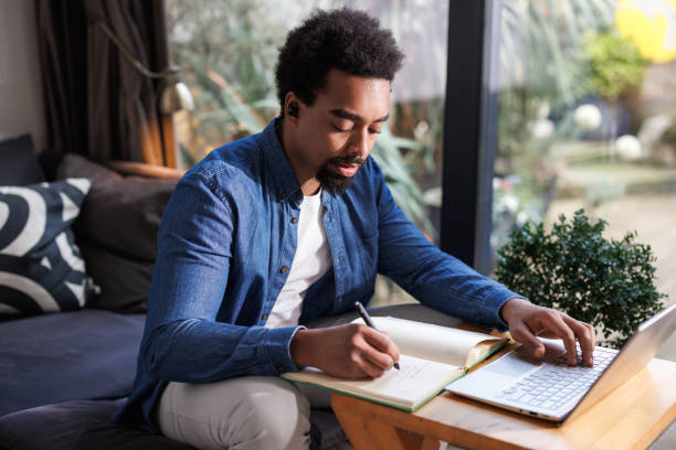 istock African American man working on a laptop at home 2203943003