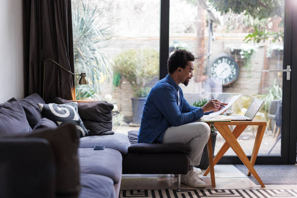 istock Man at home managing finances and reviewing paperwork 2203943019