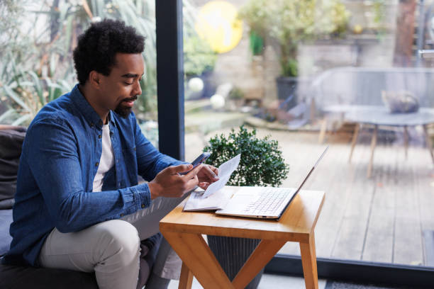 istock Man sitting at home organizing and paying bills 2203943034