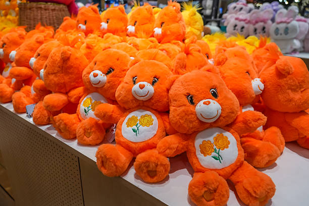istock Teddy bears toys orange colored on a store shelf in a row 2203943217