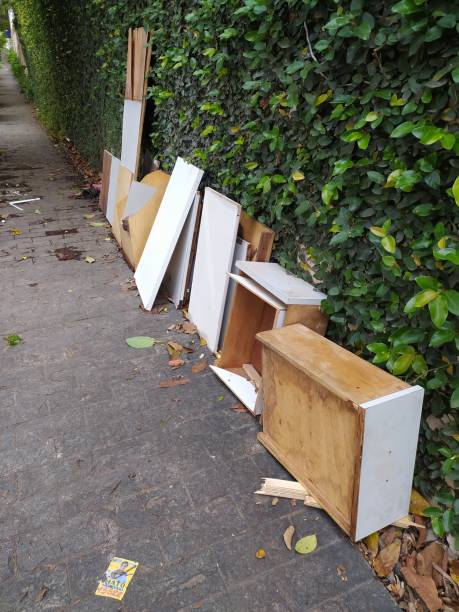 A disassembled wooden cabinet left on the sidewalk.