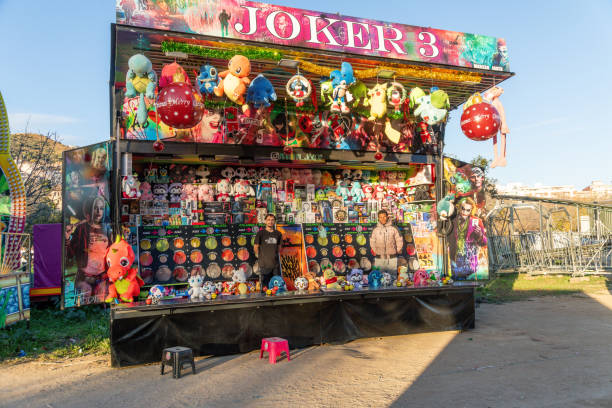 Santa Monica, United States - July 24, 2017. Close-up of a woman selling art on the santa monica pier, while seking shelter from the sun under a colorful umbrella.