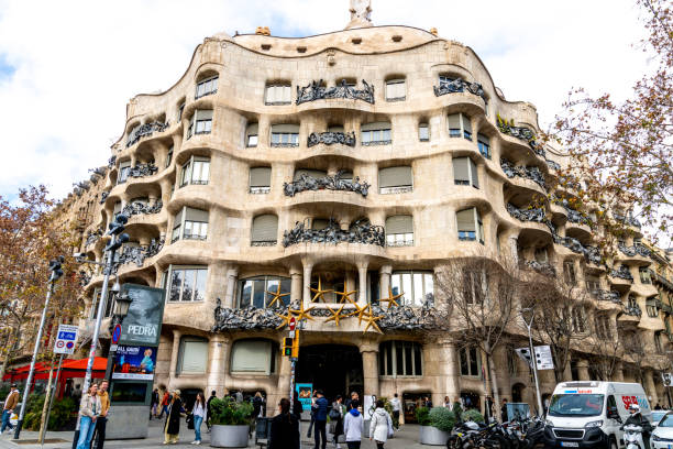 Casa Milàs full facade with street view Barcelona, Catalonia - Spain - 01-08-2025: Wide view of Casa Milàs undulating stone facade with wrought iron balconies, curved windows, and people walking along the street. casa mil�� stock pictures, royalty-free photos & images