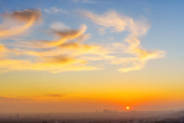 Stunning sunset over Los Angeles downtown skyline, vibrant colors, clouds, viewed from elevated vantage point