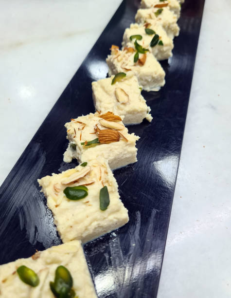 istock Elegant bakery products line a black rectangular platter, topped with nuts and showcasing creamy, rich textures that invite indulgence 2203951758