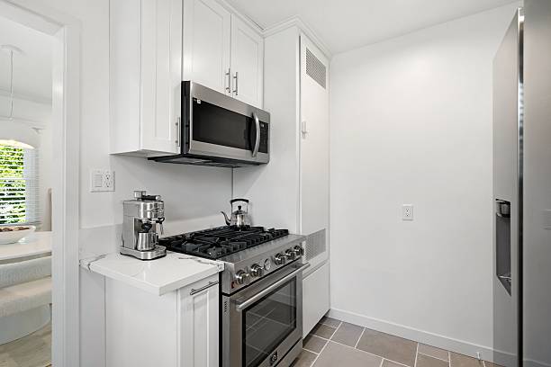 istock Bright and Modern Kitchen with White Cabinetry and Stainless Steel Appliances 2203955924