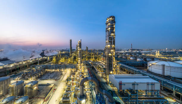 istock Industrial plant at twilight with lights illuminating structure 2203956518