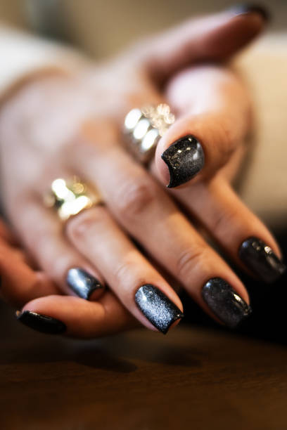 Close-up elegant woman's hand with shiny black nails.