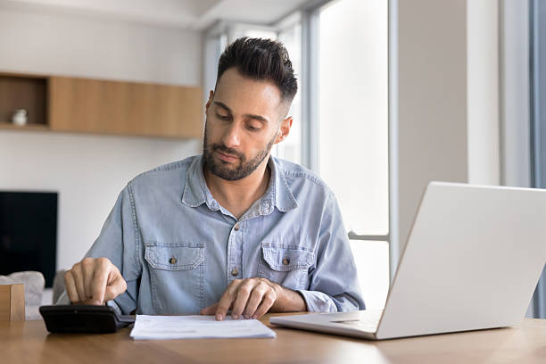 istock Focused man engaged in financial work seated at table 2203960384