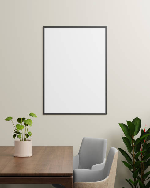 istock A modern black frame on a neutral wall, complemented by a plant and a table with chairs, perfect for showcasing artwork or photographs. 2203961835