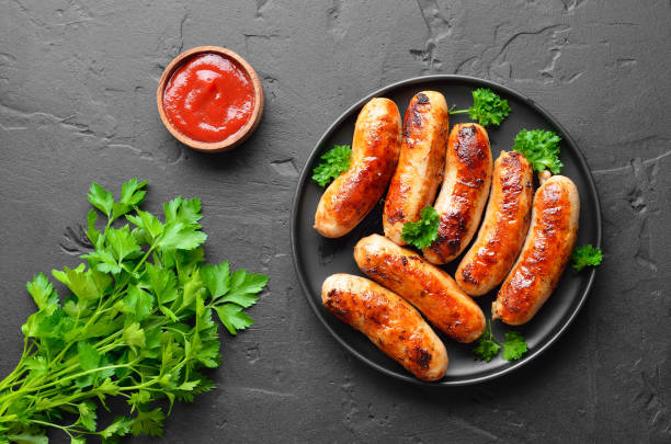 istock Roasted sausages on plate, top view 2203962040