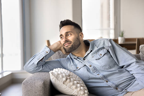 istock Hispanic man relaxing leaning on comfortable sofa in contemporary room 2203962682