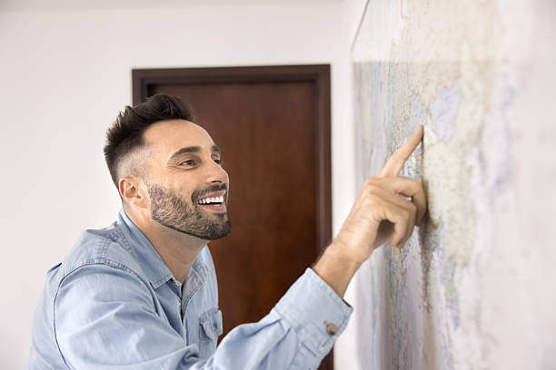 istock Closeup of Hispanic man pointing on location at world map 2203963220