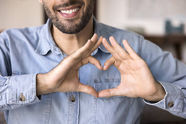 istock Man makes heart gesture with his joined fingers, closeup 2203965162