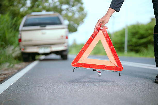 istock Roadside assistance at a vehicle breakdown with warning triangle in hand during daylight 2203965739