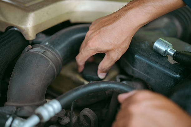 istock Mechanic inspecting engine of vehicle during daytime repair in workshop setting 2203966521