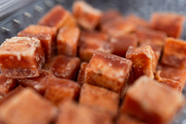 A detailed close-up macro shot of natural brown sugar cubes, showcasing their rich texture and caramelized color. Perfect for sweetening beverages and desserts in a healthier way.