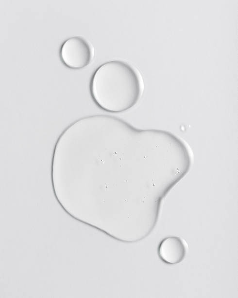 istock Transparent cosmetic serum drops on a light background 2203967725