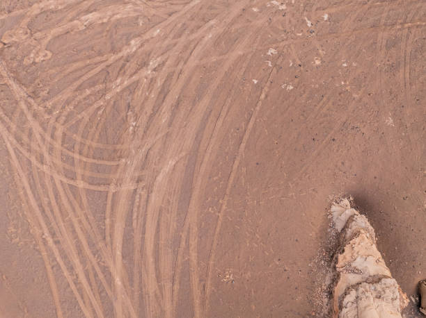 istock Desert sand ground with many vehicle tire tracks 2203968200