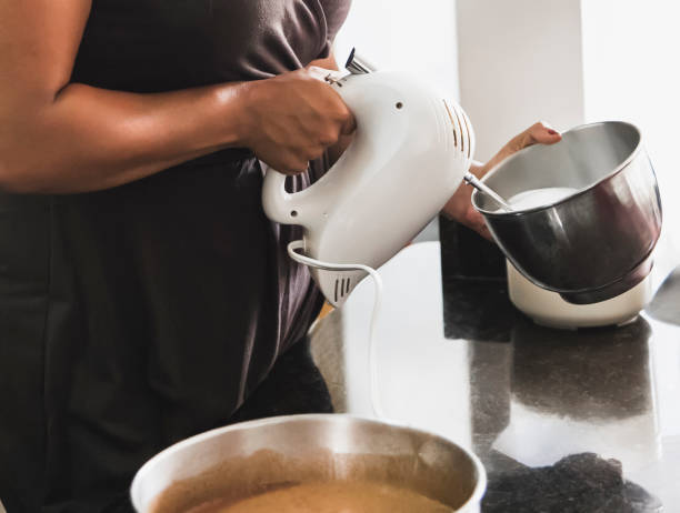 istock Pastry chef whisking ingredients with electric mixer in kitchen 2203968391