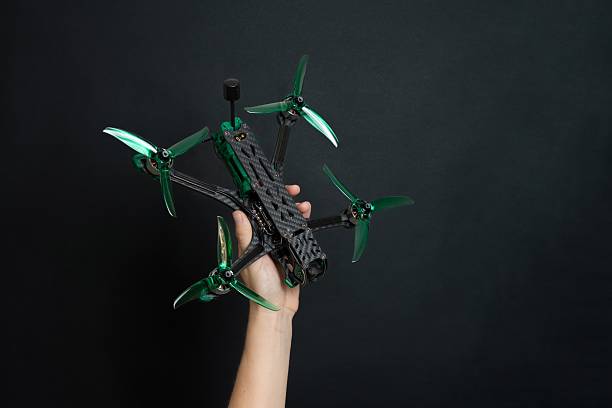 istock Professional modern drone with digital camera in hand on black background 2203973153
