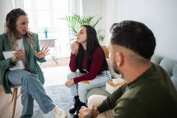 istock Therapist listening to young couple discussing problems during therapy session 2203975961