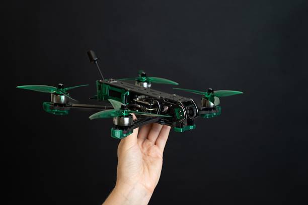 istock Professional modern drone with digital camera in hand on black background 2203977703
