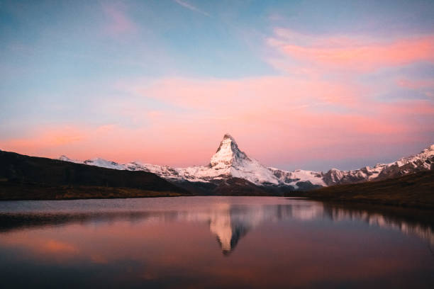 Alpenglow on Stellisee Lake and Matterhorn Peak, reflection of mountain and forest in lake, Valais, Swiss Alps