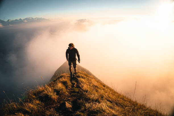 Hiker explores trail on mountain ridge at sunrise